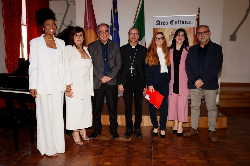 Foto di gruppo davanti al pannello di Area Cultura alla cerimonia del Premio William Shakespeare 2024